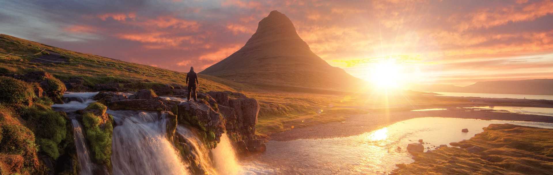 Silhouette of a man standing in front of Kirkjufoss and Kirkjufell mountain, Iceland