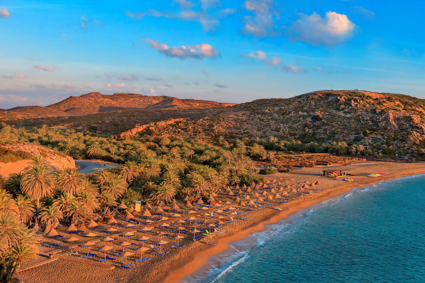 Long strand of beach with umbrellas in Crete