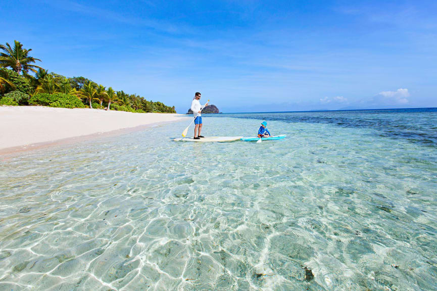 Father and son standup paddle boarding in Fiji