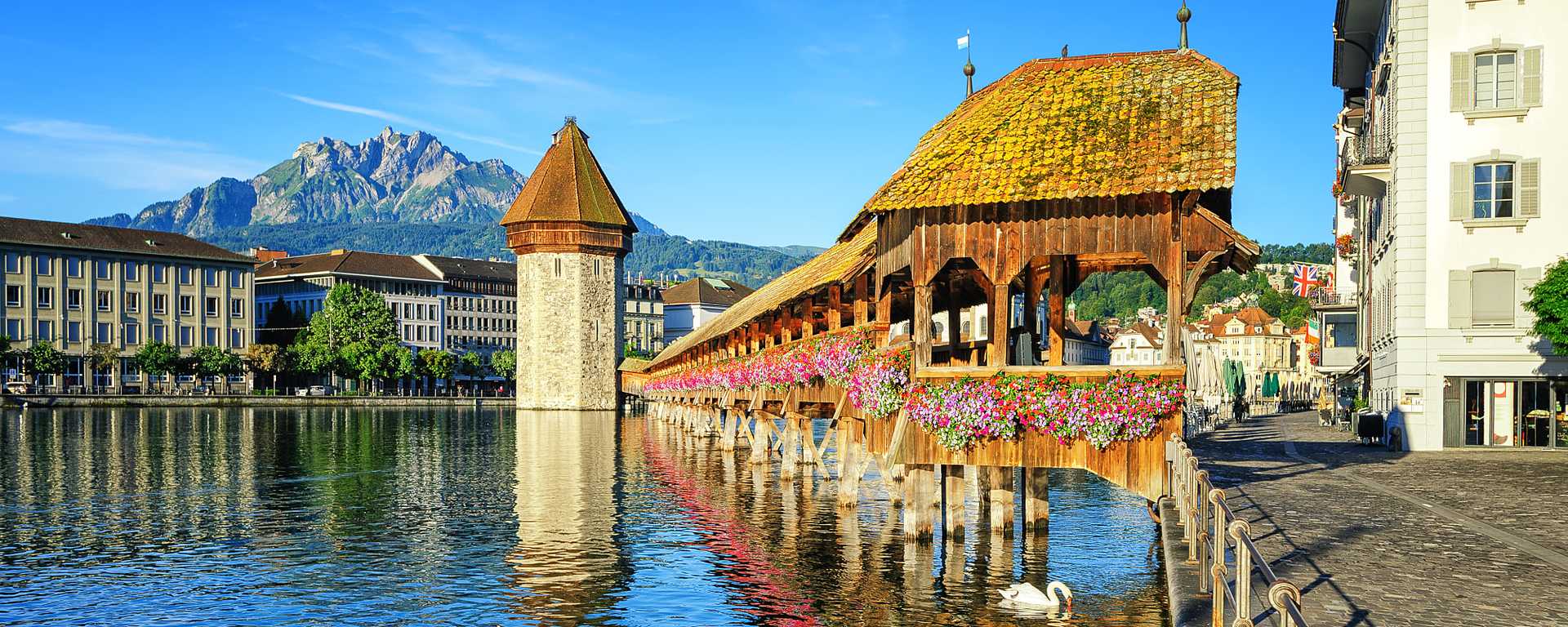 Flower covered wooden chapel bridge and water tower in Lucerne, Switzerland