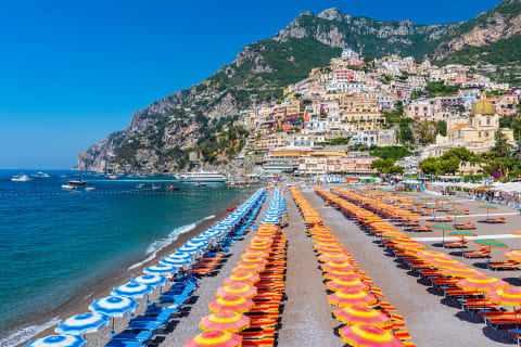 Orange and blue umbrellas on the beach in Positano on the Amalfi Coast of Italy