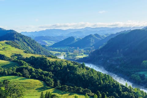 Beautiful scenery of river winding though green treed hills and mountains in Whanganui National Park in New Zealand